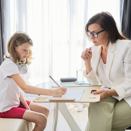 Child psychologist talking to girl kid in office