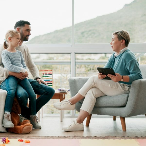 Father, child and woman with tablet in office for psychology consultation, therapy session and lear